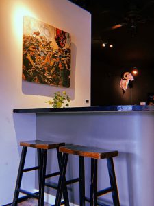 a bar with stools and a painting on the wall