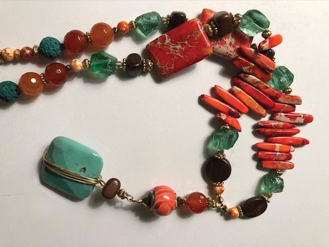 Title: “Sunset”
Medium: Gemstones/orange,
turquoise wood, glass, gold metal
Size: 24 inch necklace with 4 inch
pendant