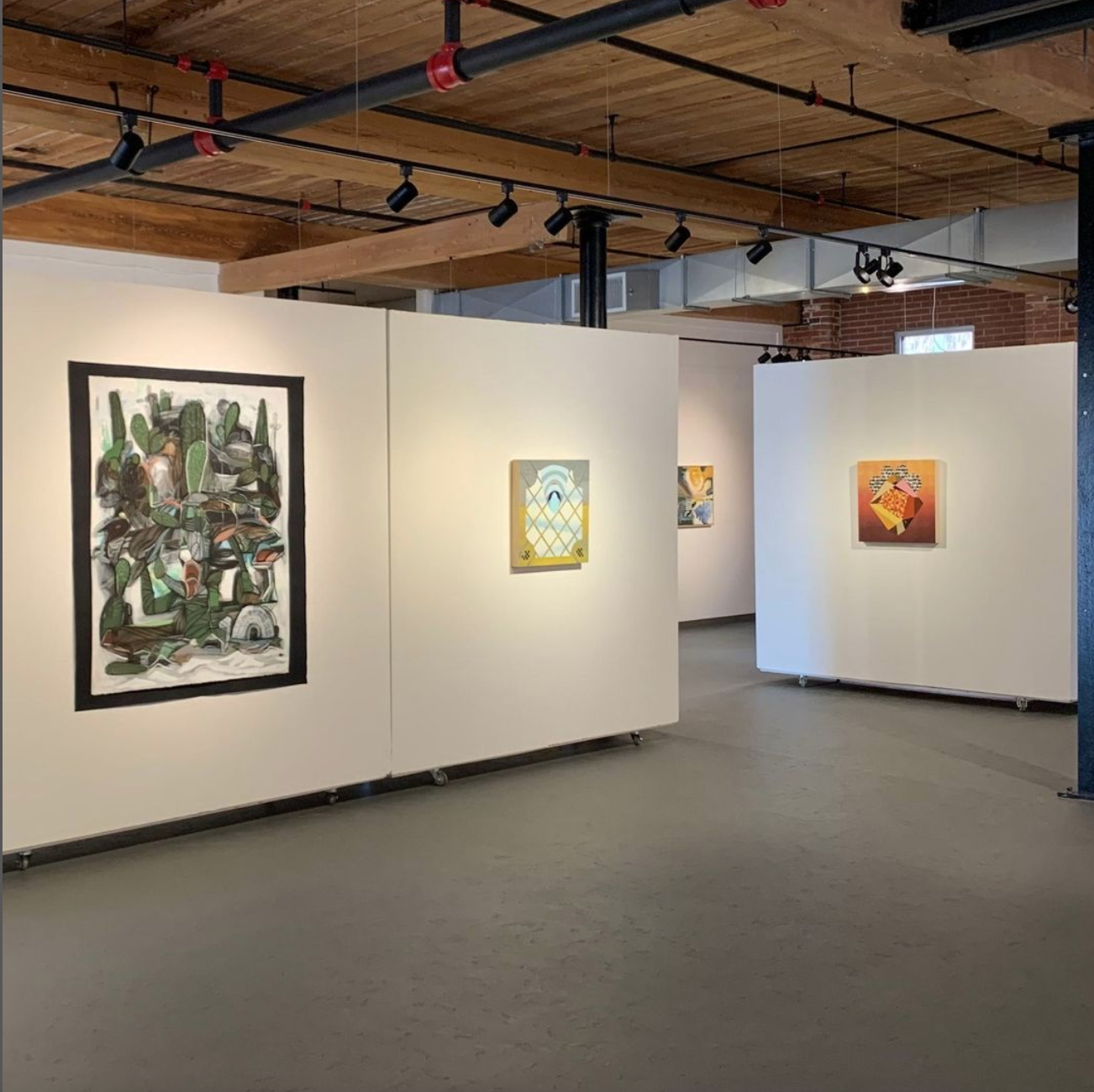a room with white walls and paintings