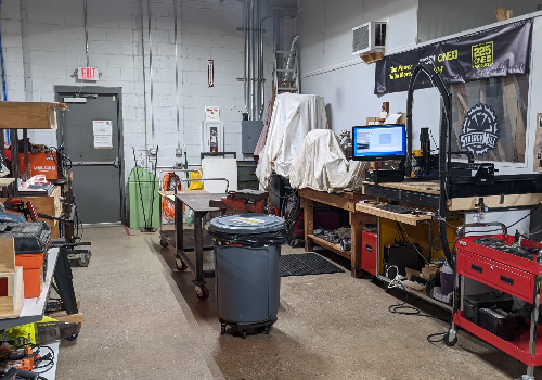 a room with a computer and a trash can