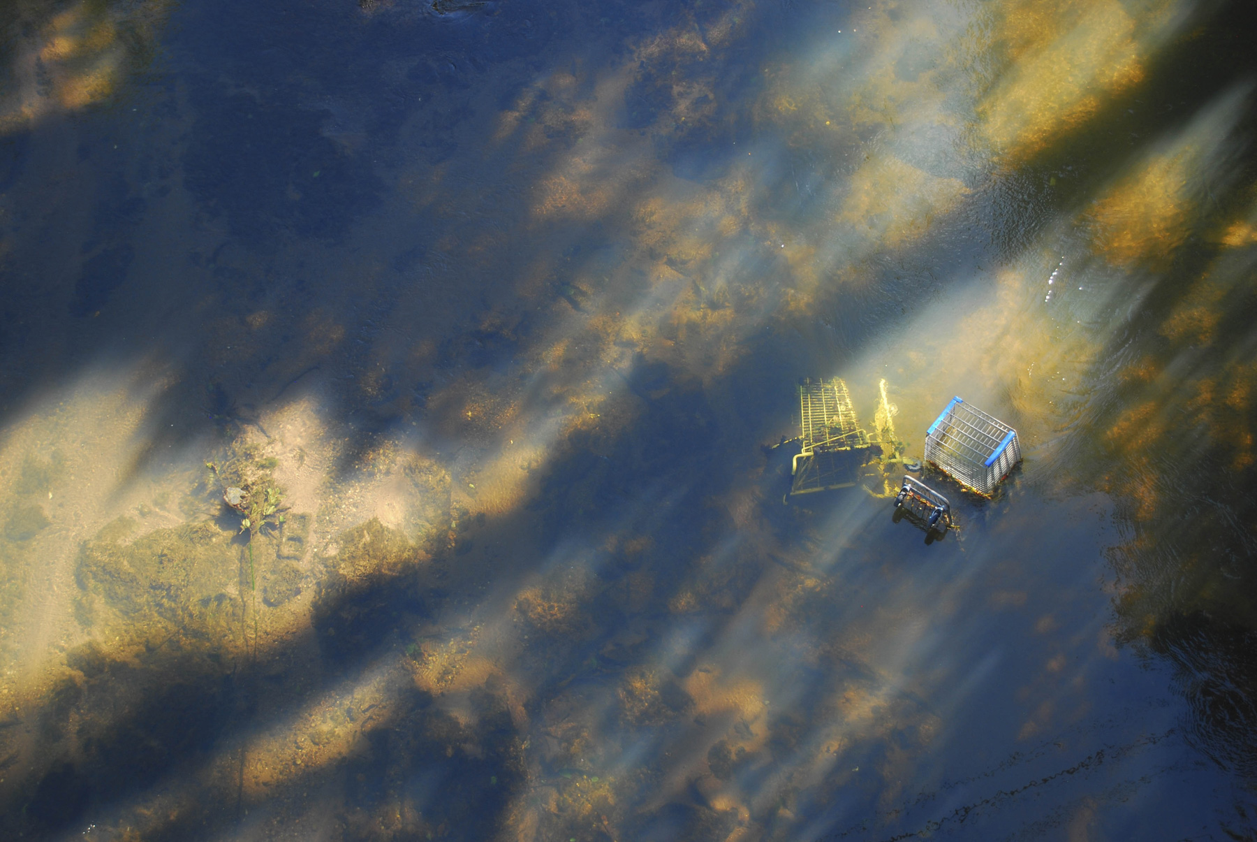 a aerial view of a river with shopping carts in the water