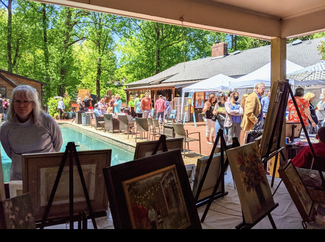 a group of people outside with art and a pool
