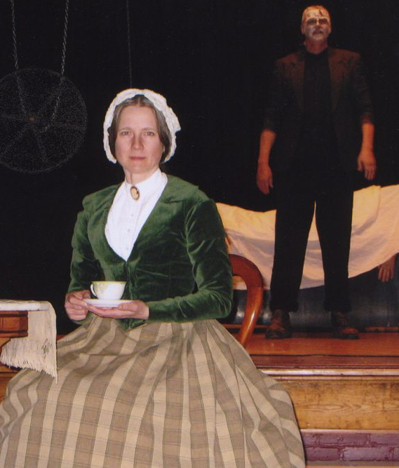 a woman in a green dress holding a cup