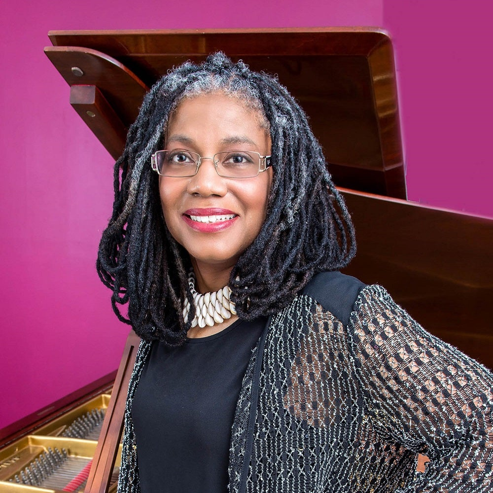 a woman with braided hair and a piano