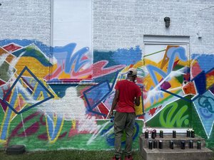 a man painting a wall with graffiti