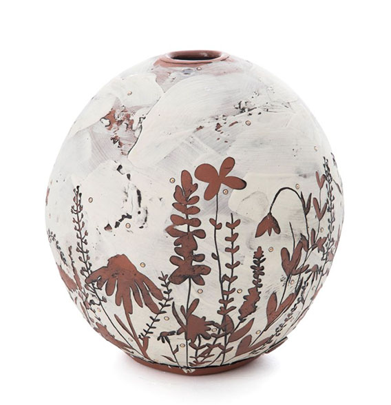 a round white and brown vase with flowers and leaves painted on it