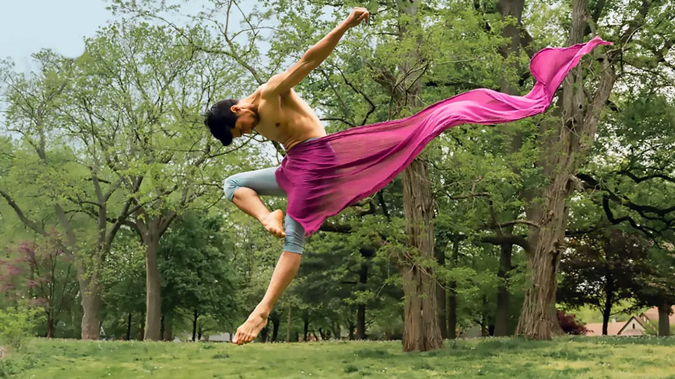 a man in a pink skirt jumping in the air