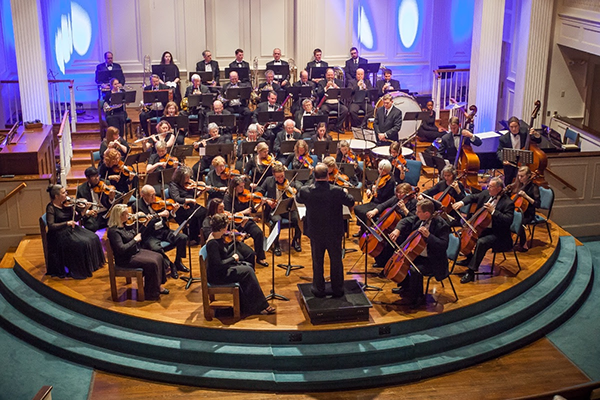 a orchestra with a conductor in front of him