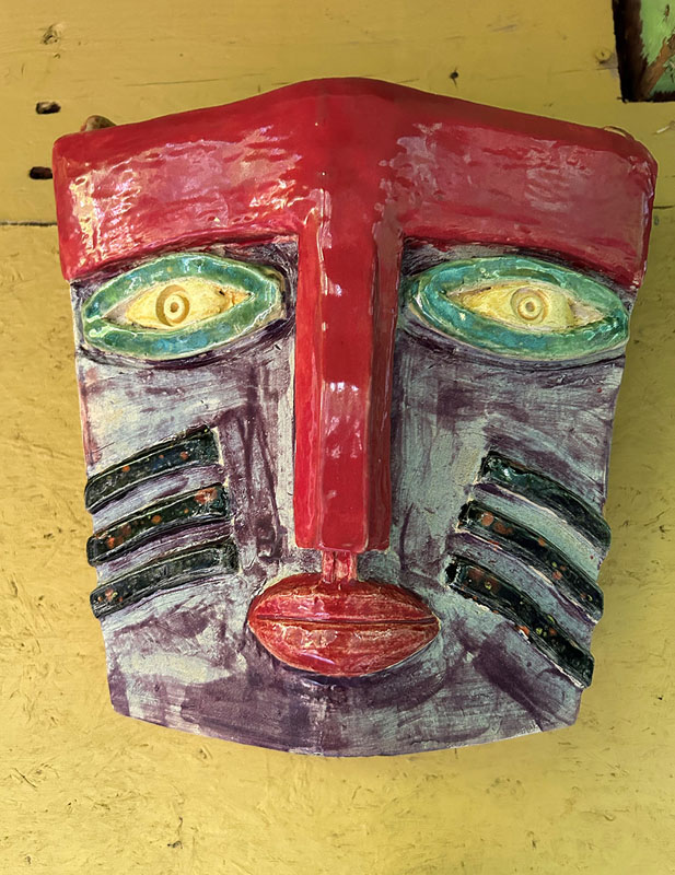 a ceramic face on a yellow surface