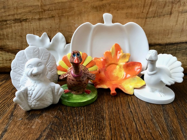 a group of ceramic turkeys and a pumpkin