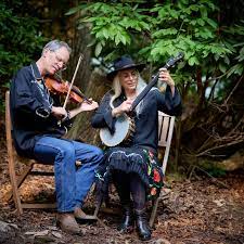 a man and woman playing instruments in the woods