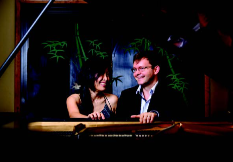 a man and woman sitting at a piano