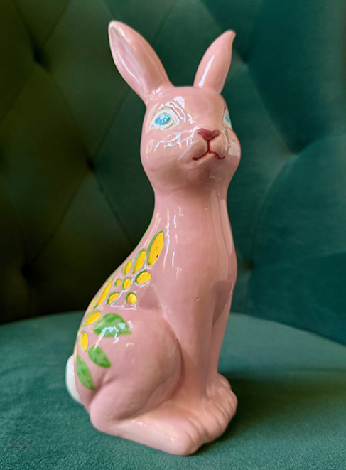 a pink rabbit statue on a green chair