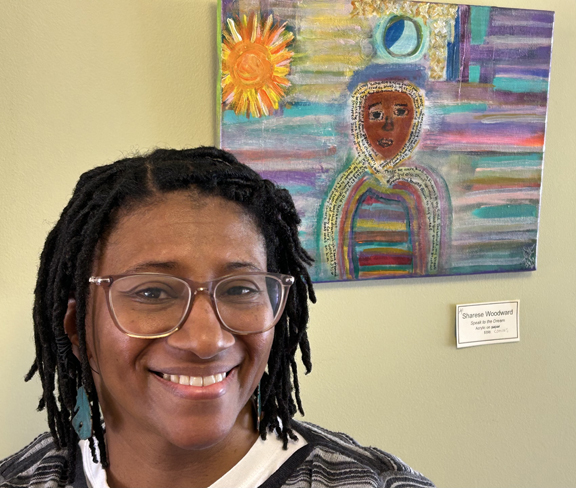 a woman smiling in front of a painting