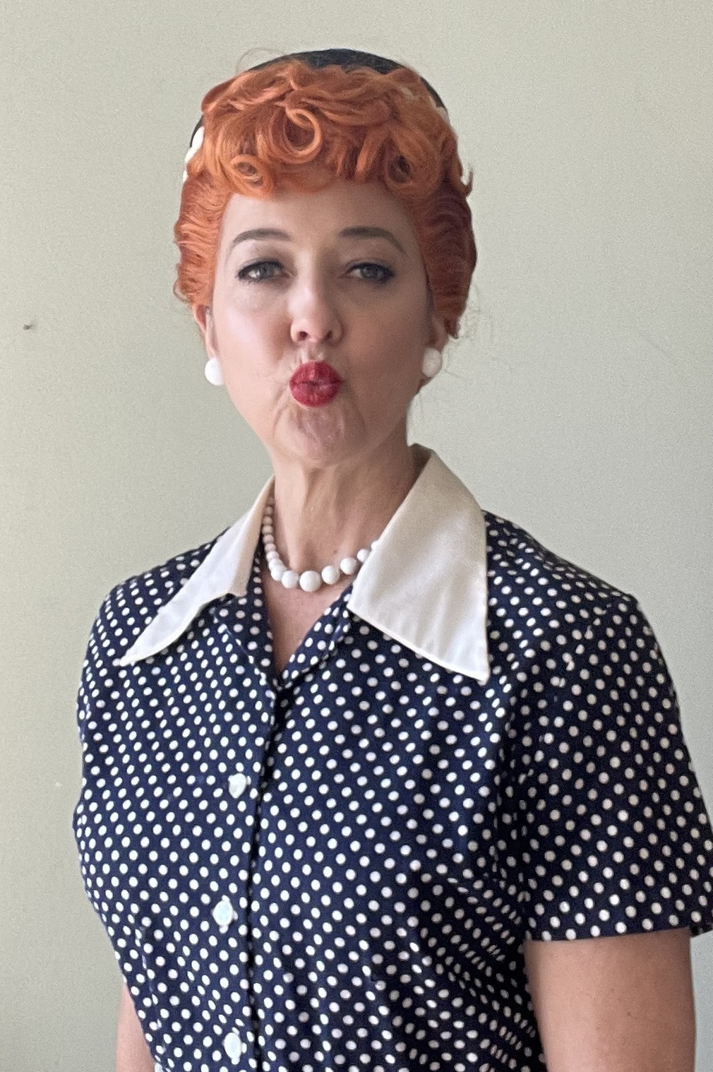 a woman with red hair and polka dot shirt