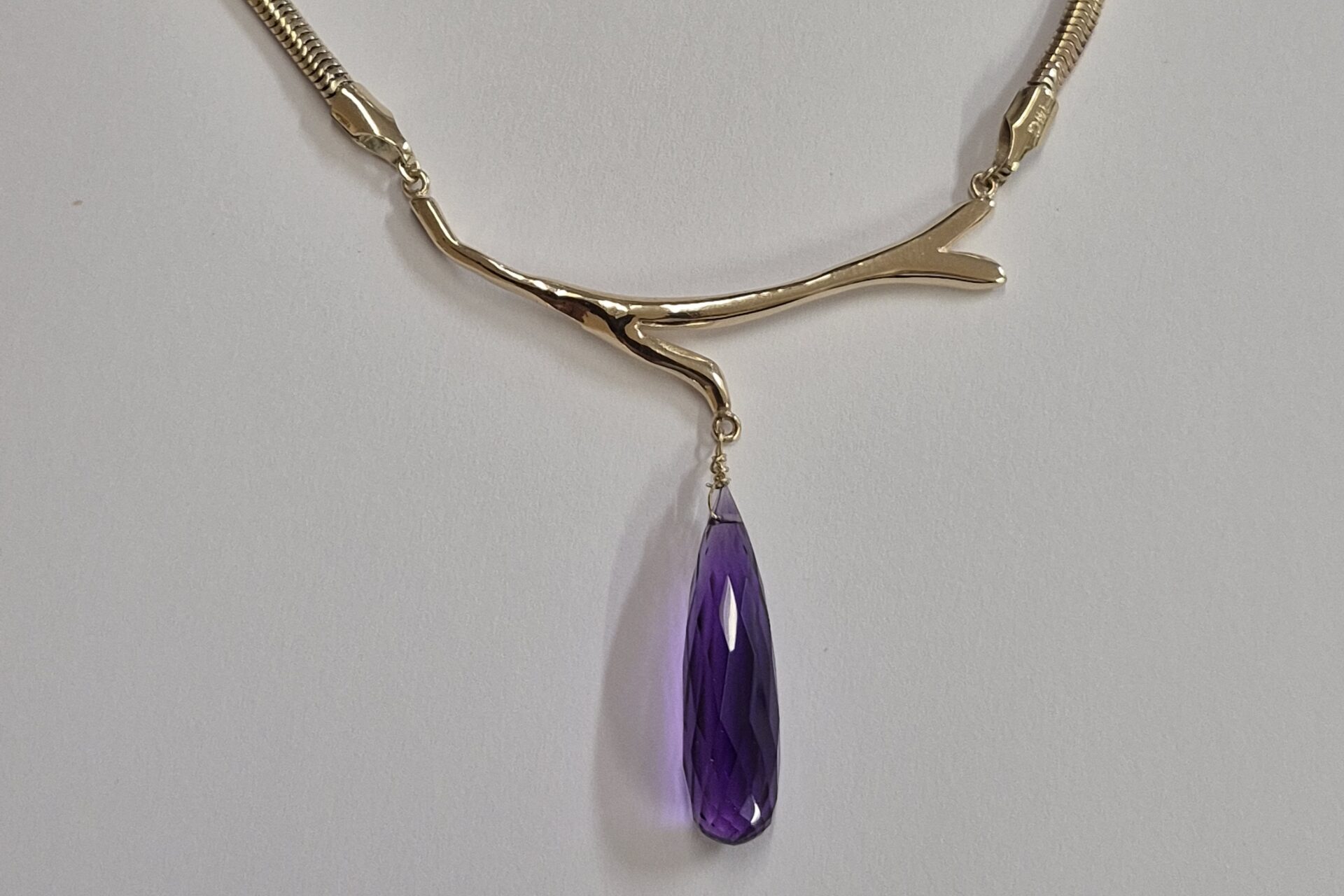 a necklace with a purple stone pendant