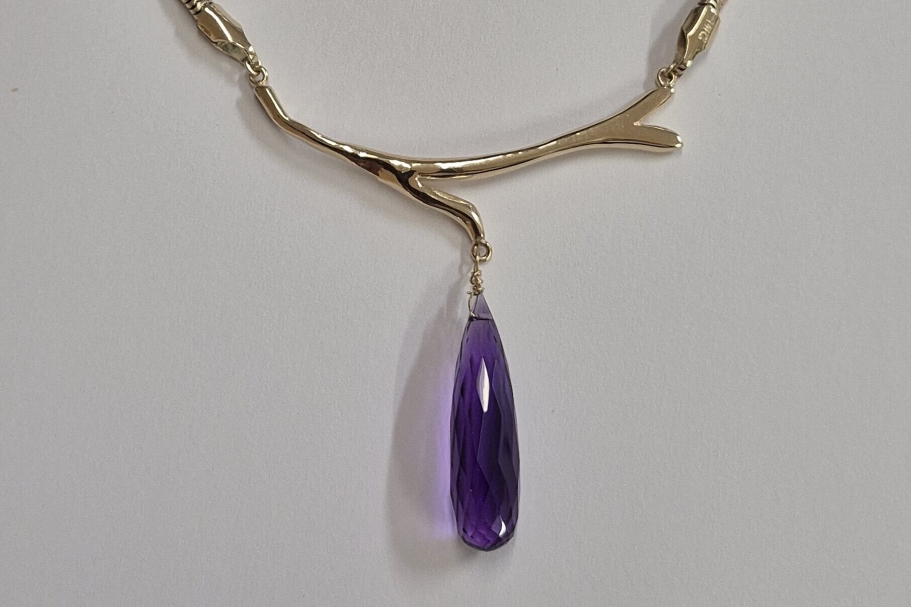 a necklace with a purple stone pendant