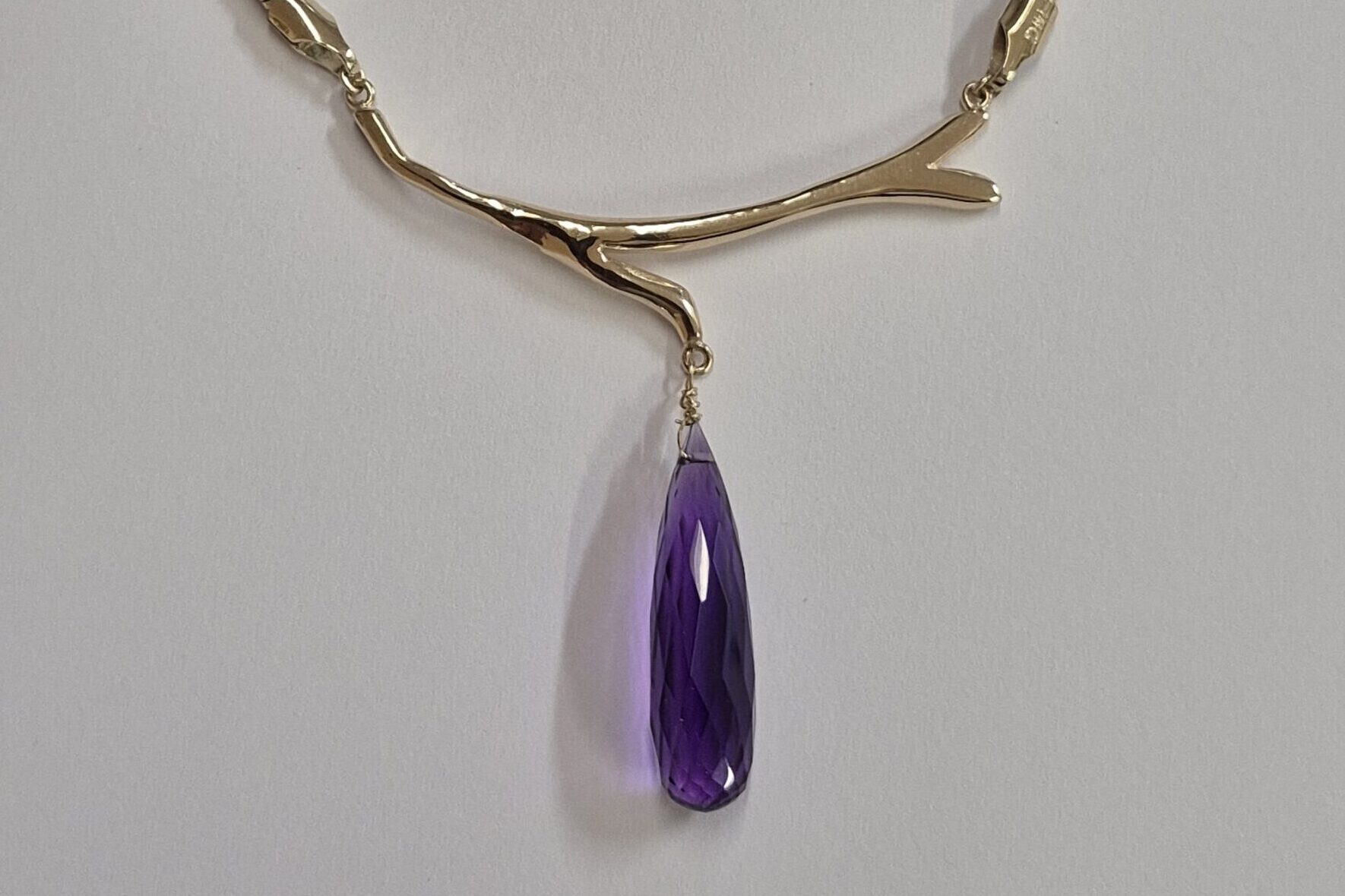 a necklace with a purple stone pendant