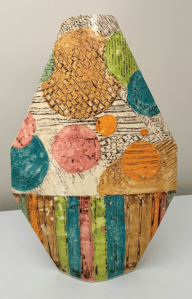 a ceramic vase with colorful circles and stripes
