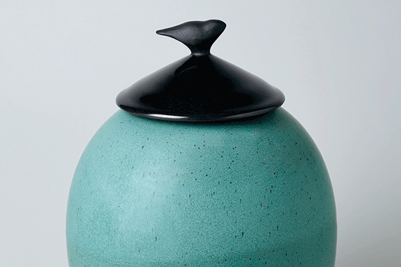 a blue ceramic jar with a black lid
