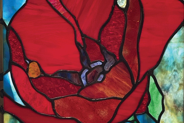 a stained glass window with a red flower