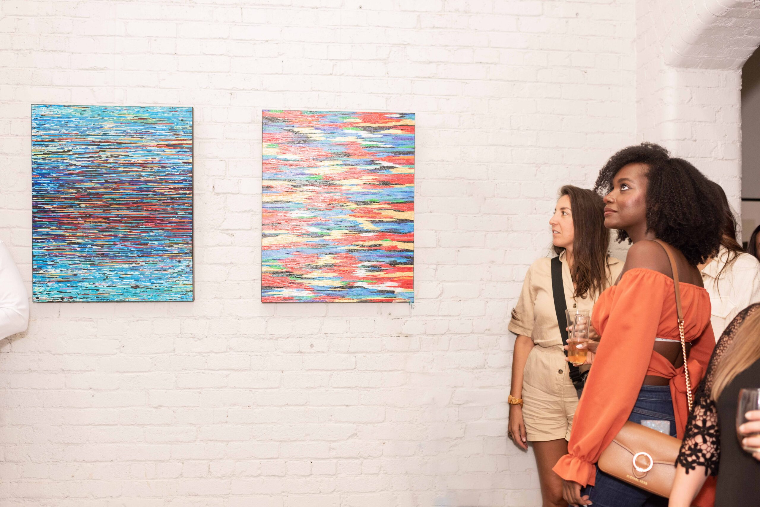 a group of women looking at art on a wall