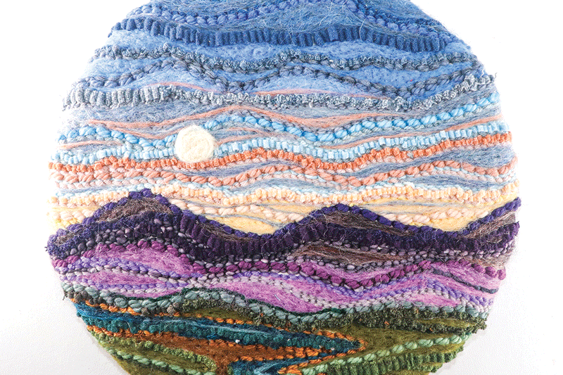 a circular object with a landscape and moon