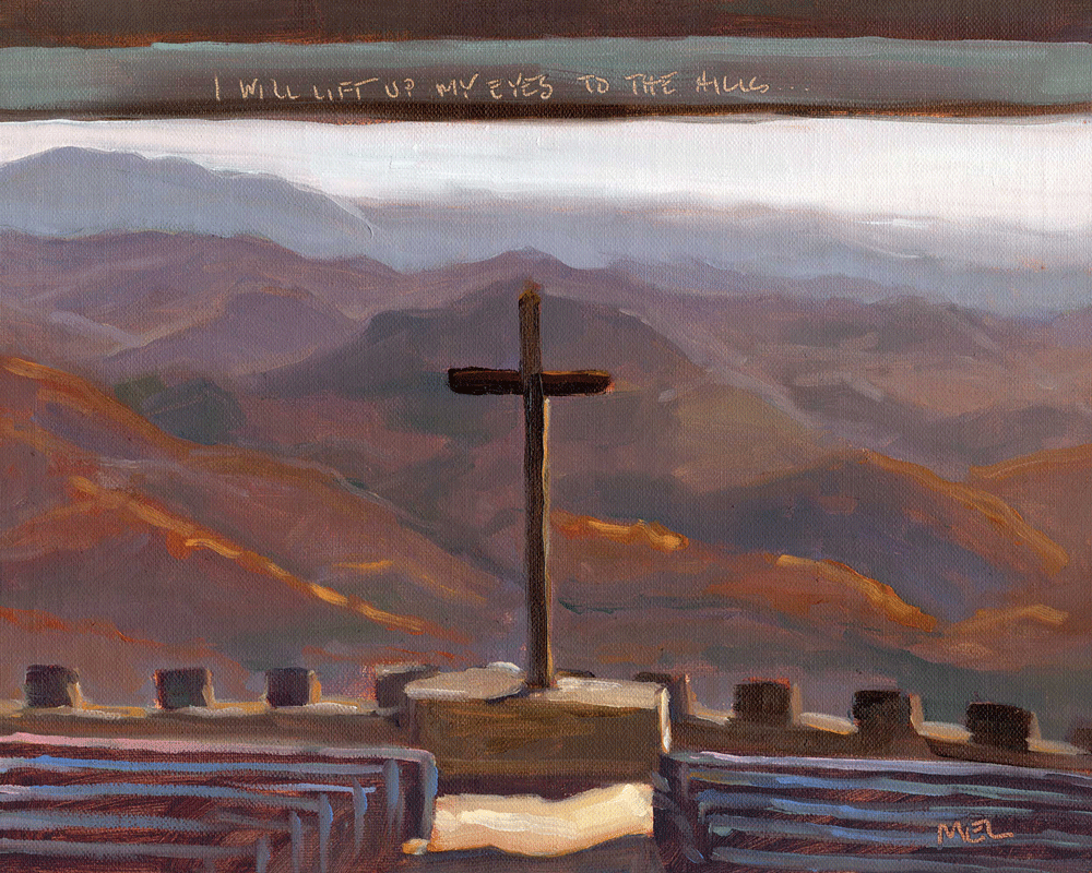 a cross on a platform in front of a mountain range