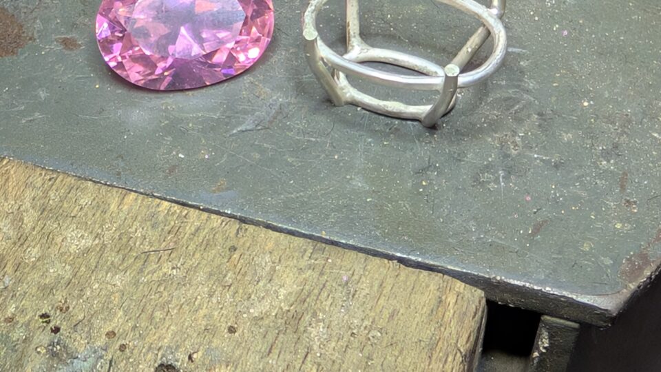 a pink gem on a metal surface
