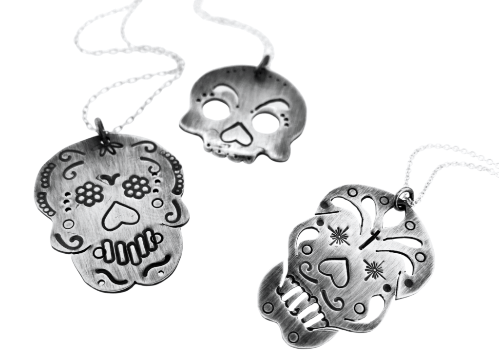 a group of silver skulls necklaces