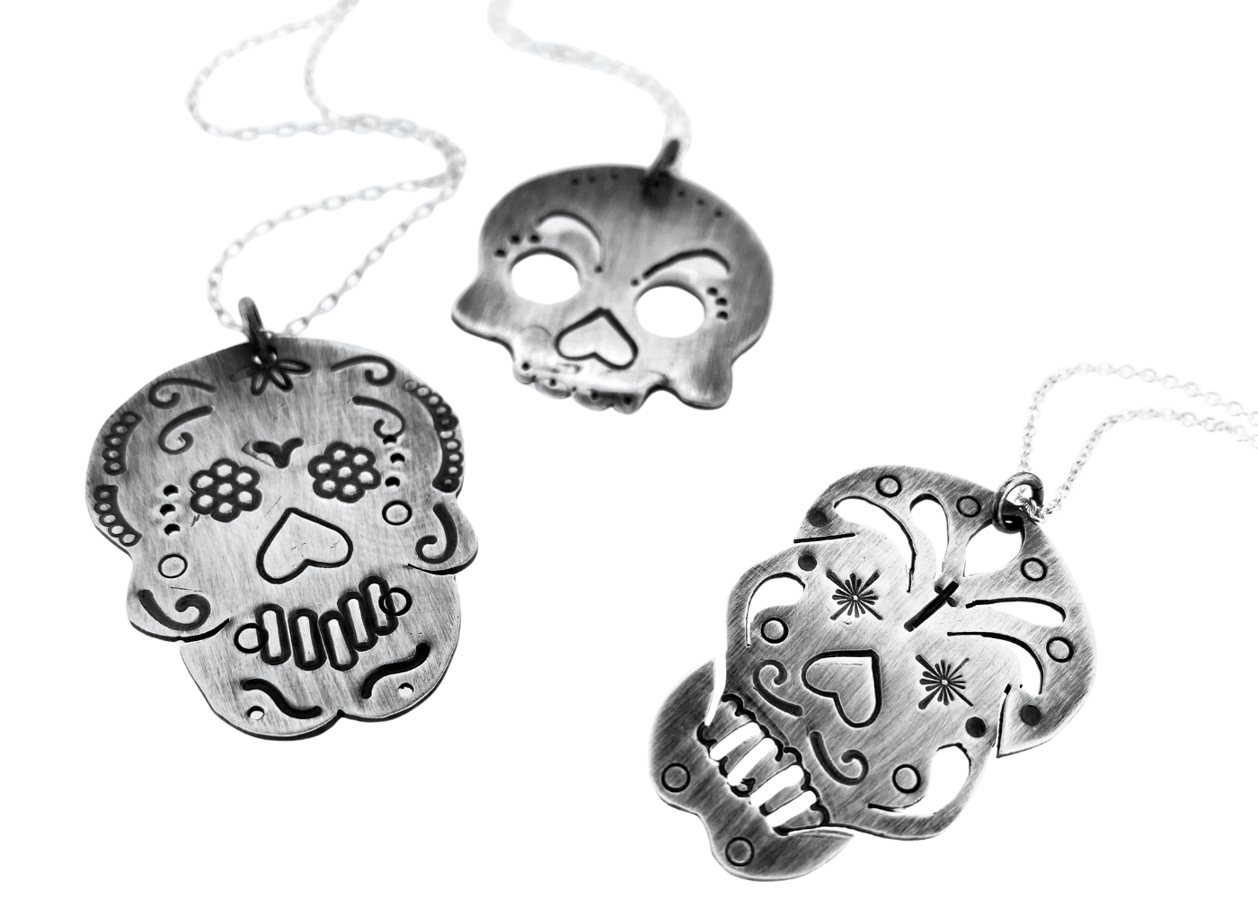 a group of silver skulls necklaces