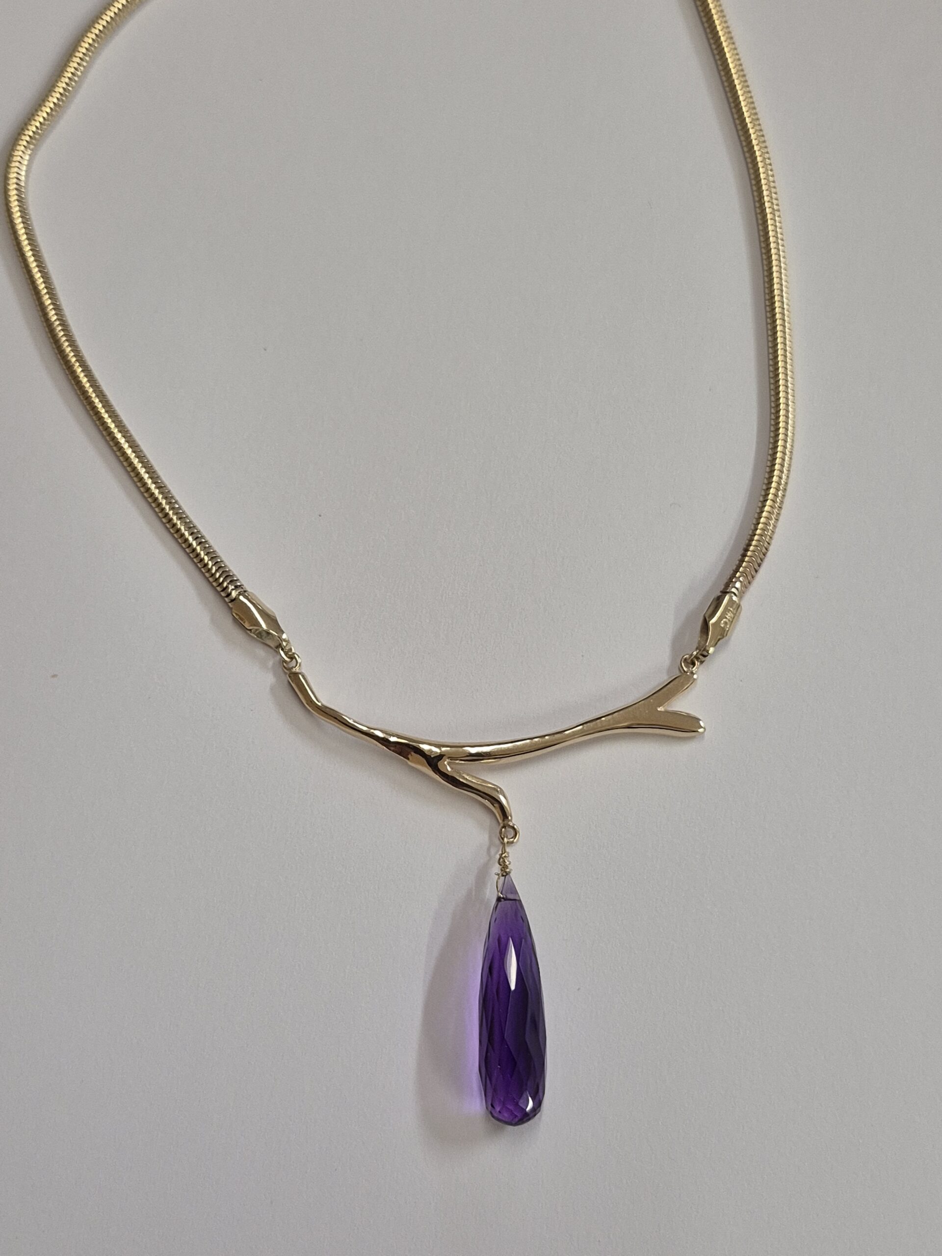 a necklace with a purple stone pendant
