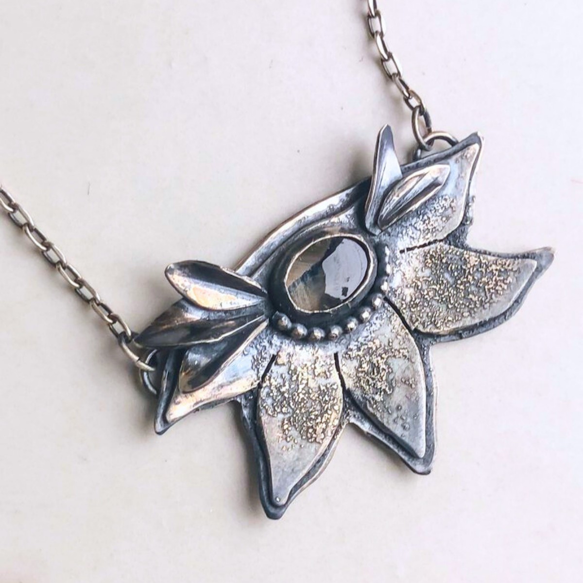a necklace with a flower shaped pendant