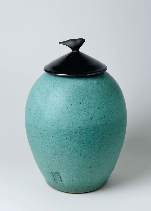 a blue ceramic jar with a black lid