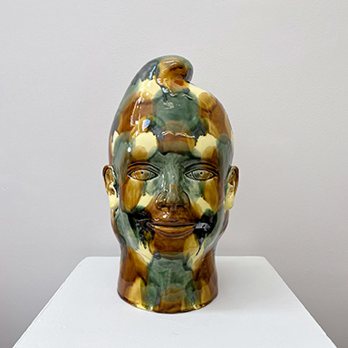 a ceramic head with a painted face