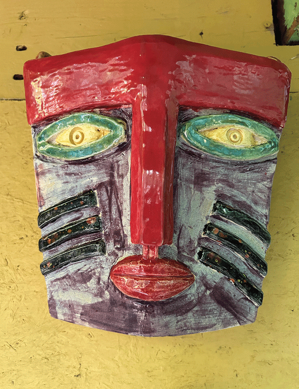a ceramic face on a yellow surface