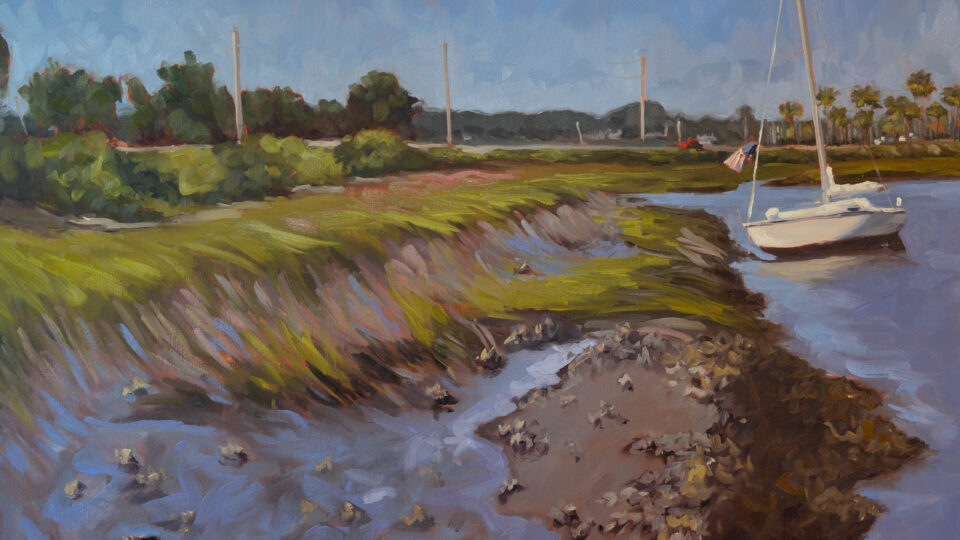 Sailboat near marshy coastal landscape