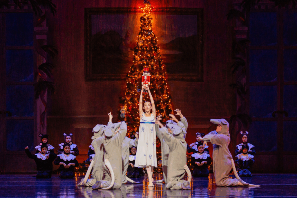 Dancers celebrating around Christmas tree.