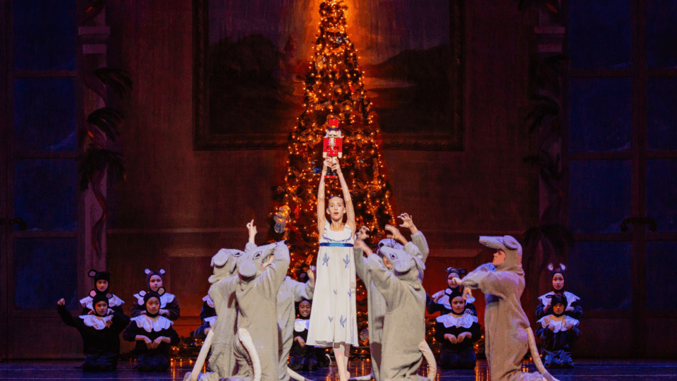 Dancers celebrating around Christmas tree.