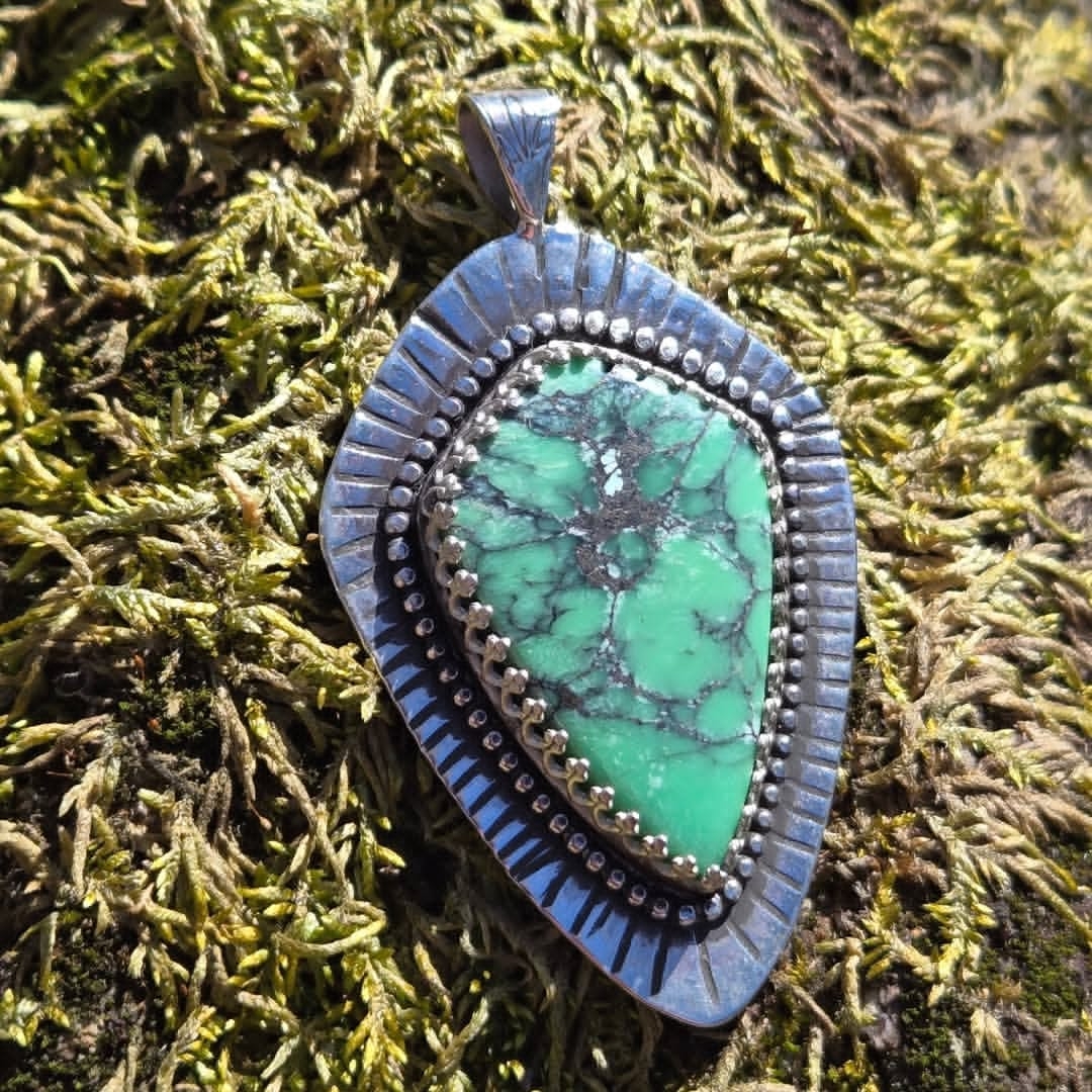 Turquoise pendant on mossy background