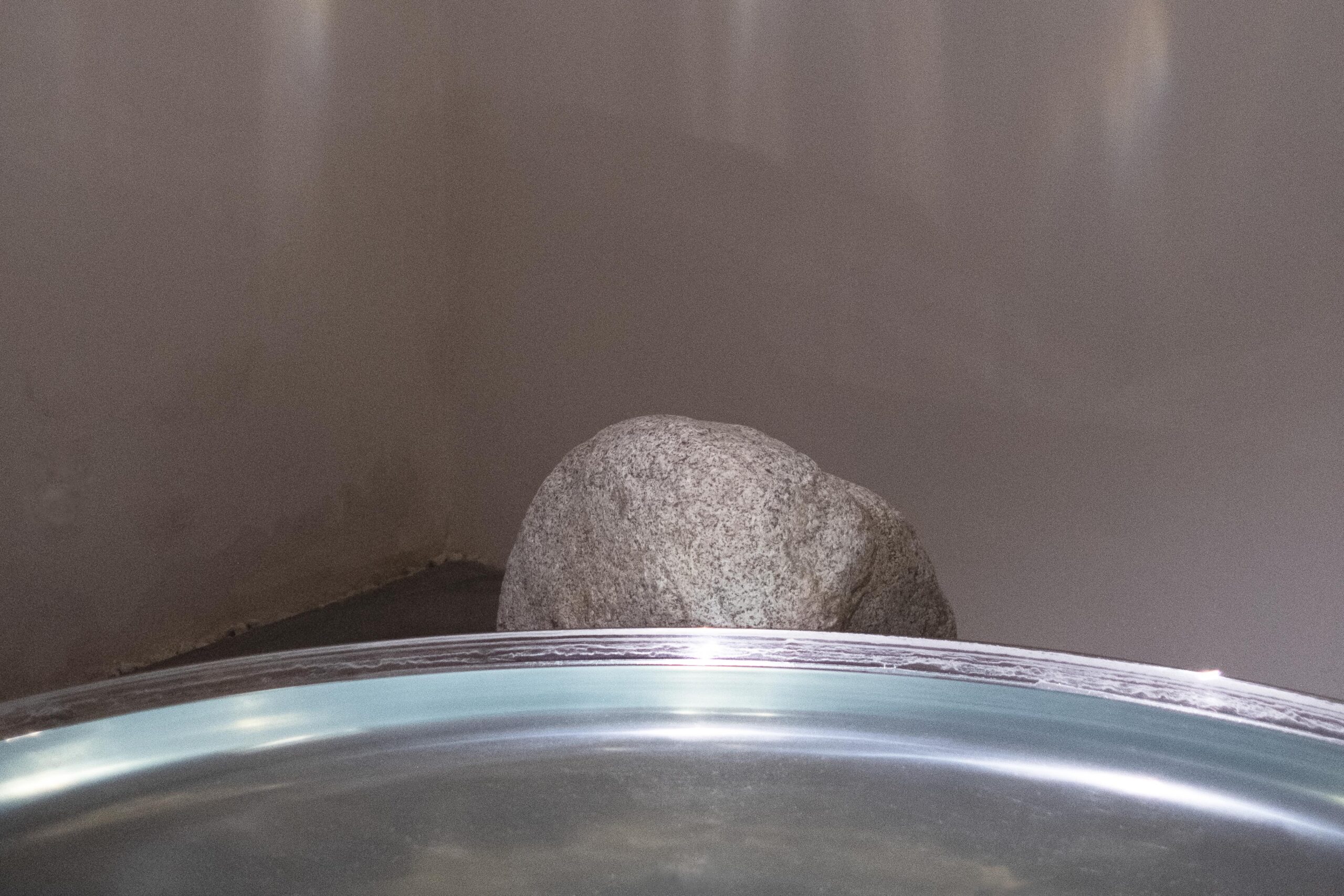 Rock behind reflective surface in room