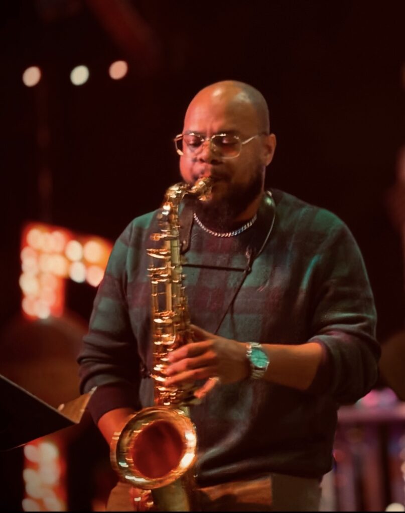 Musician playing saxophone on stage.