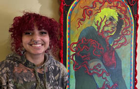 Person next to colorful artwork.