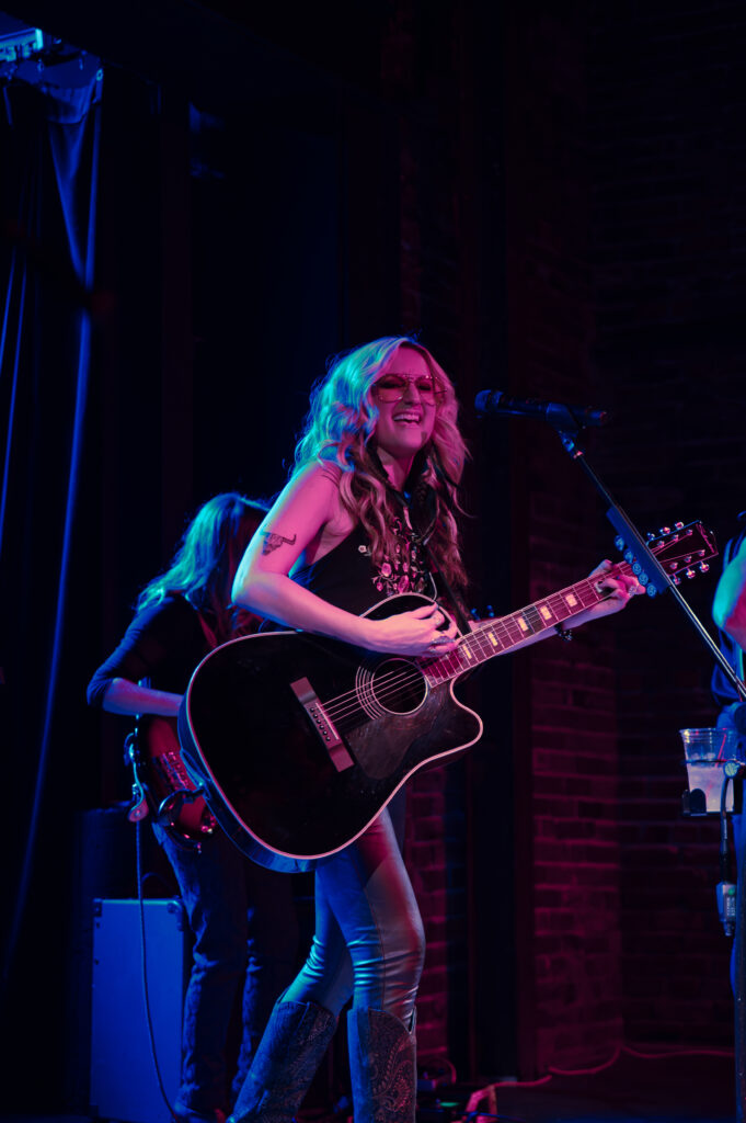 Woman playing guitar on stage