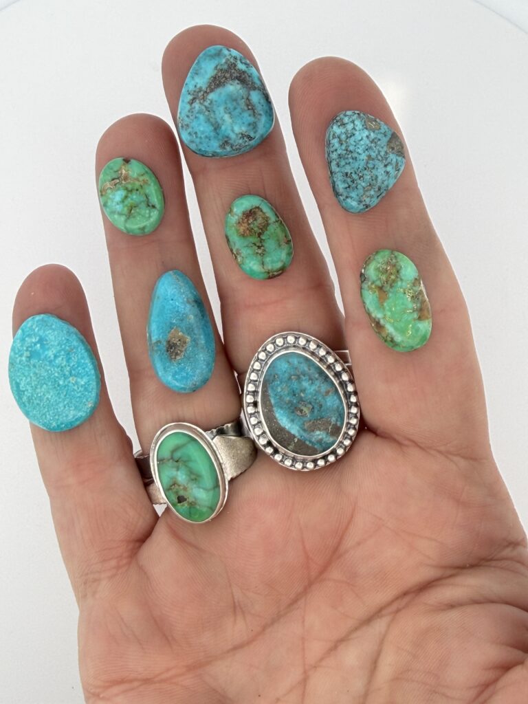 Hand displaying various turquoise gemstones