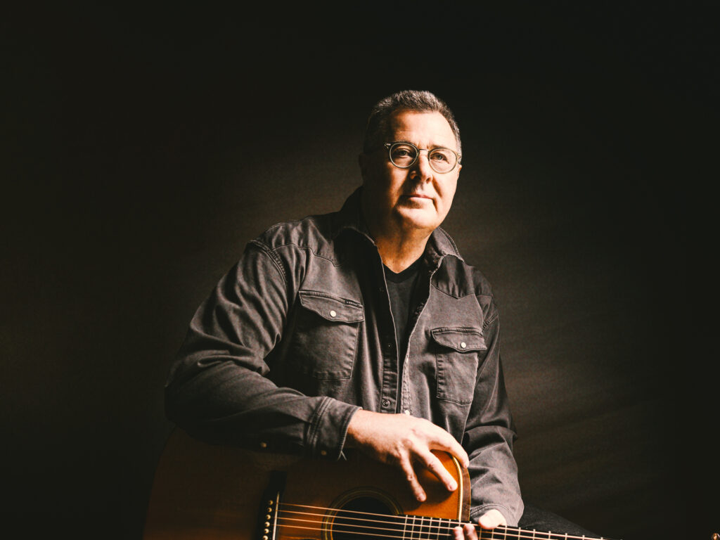 Man with guitar in dark setting