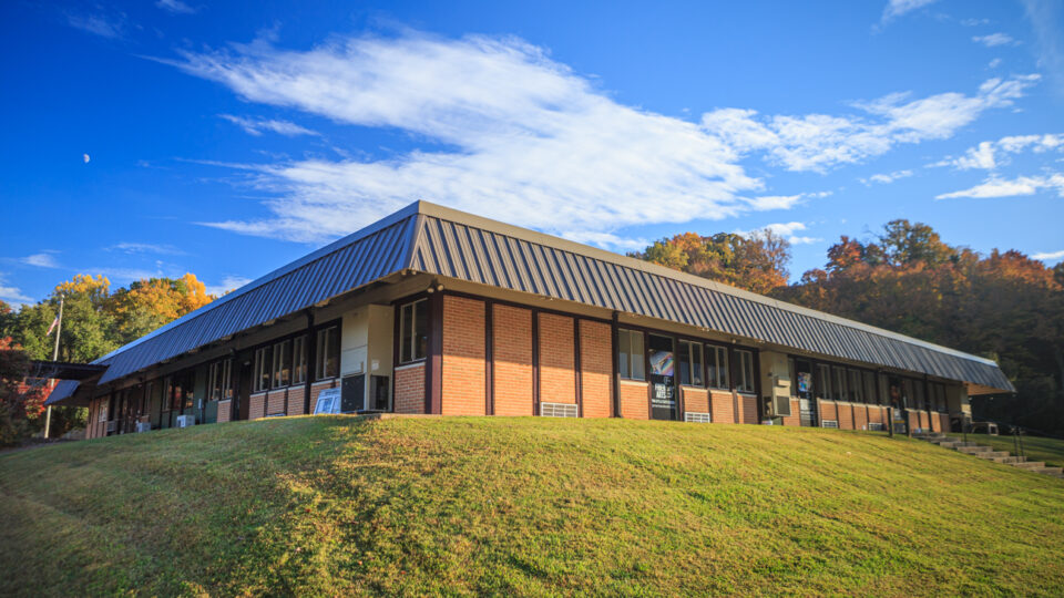 Modern building on a grassy hill.