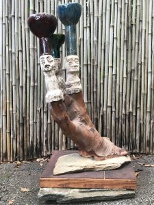 a sculpture of a tree trunk with faces on it