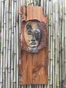 a metal face on a wood surface