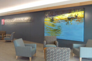 a room with chairs and a painting on the wall